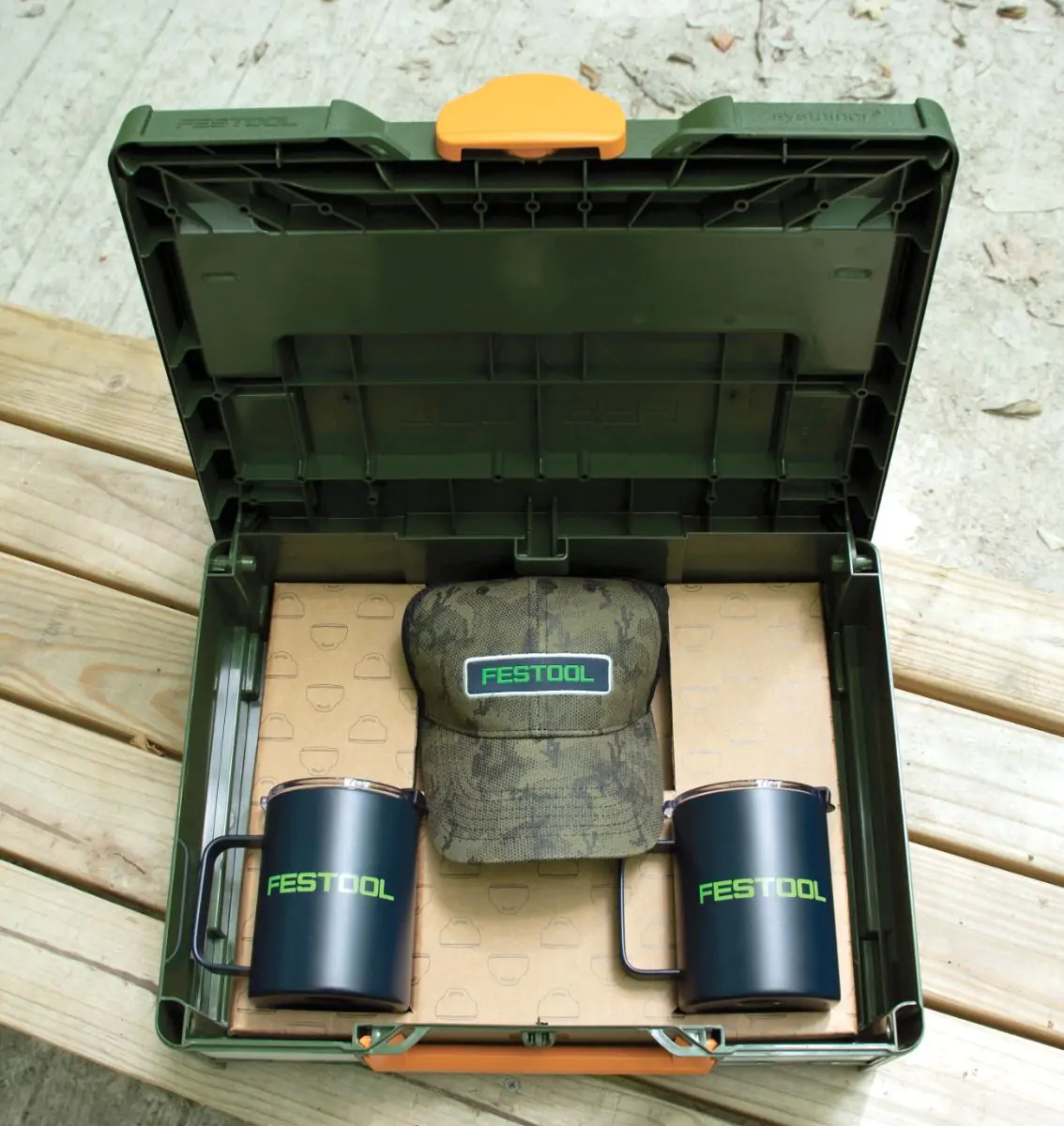 Systainer opened up to display a Festool hat and two Festool mugs. 